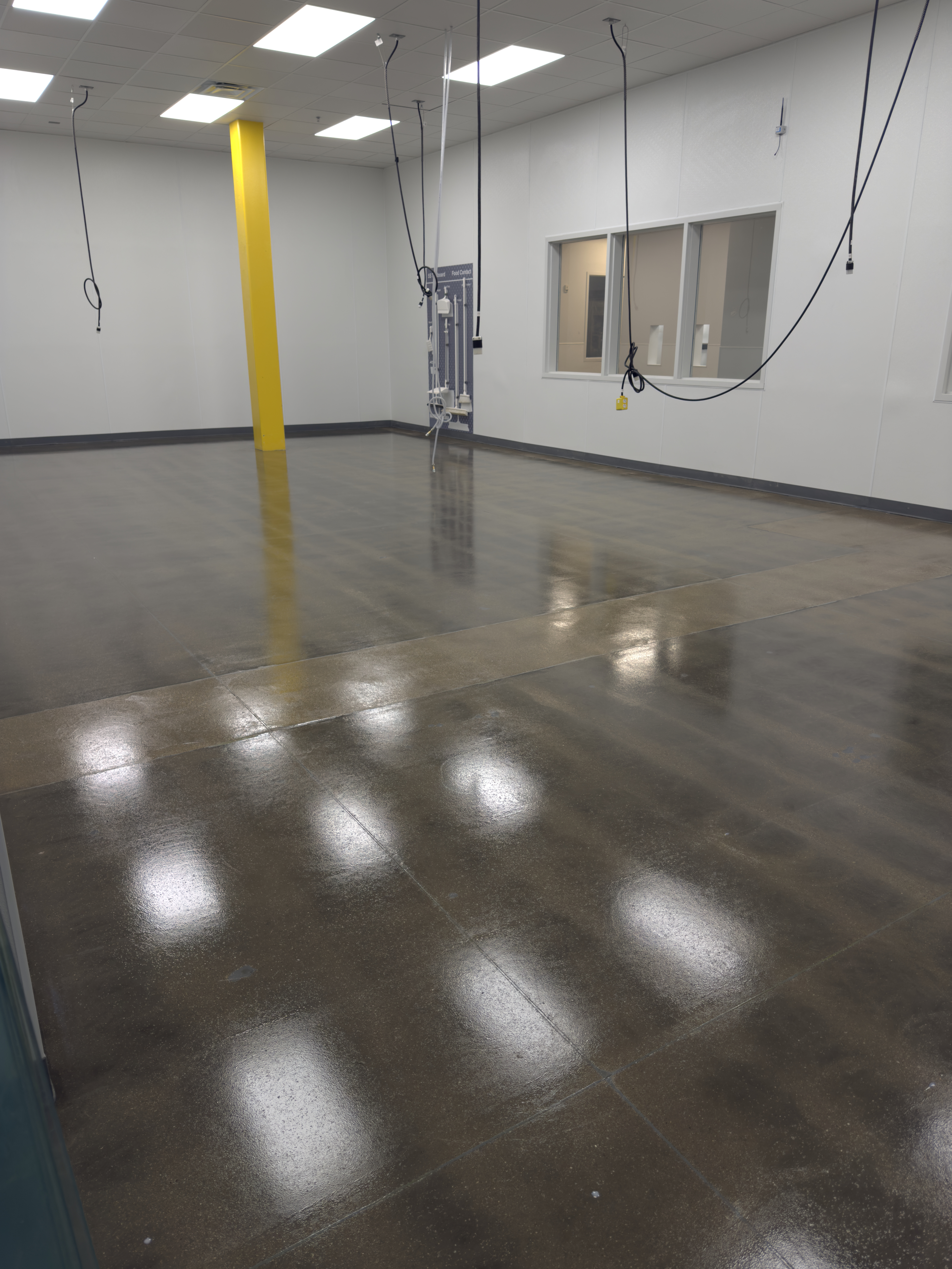 Polished concrete warehouse floor with yellow support pillar