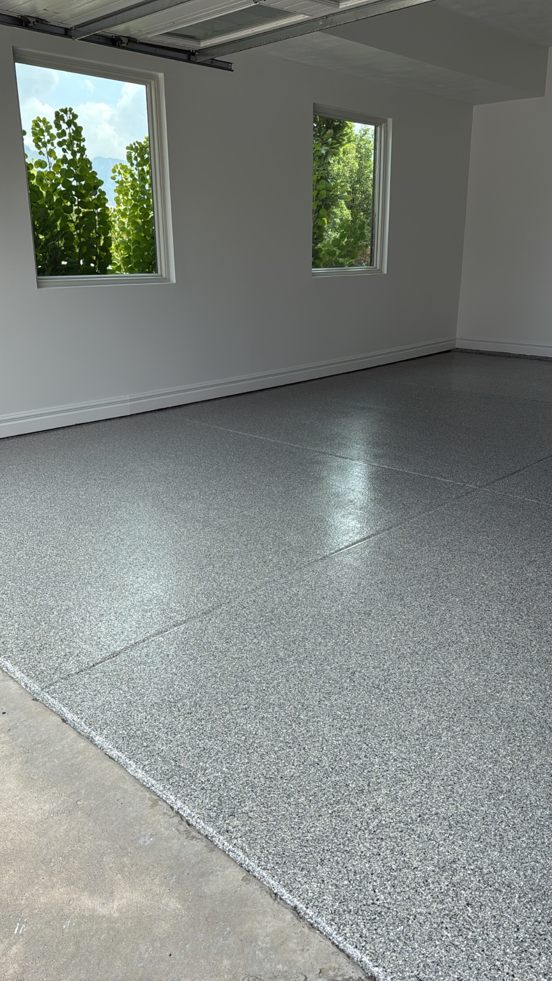 Detail of grey flake polyaspartic coating in a finished garage
