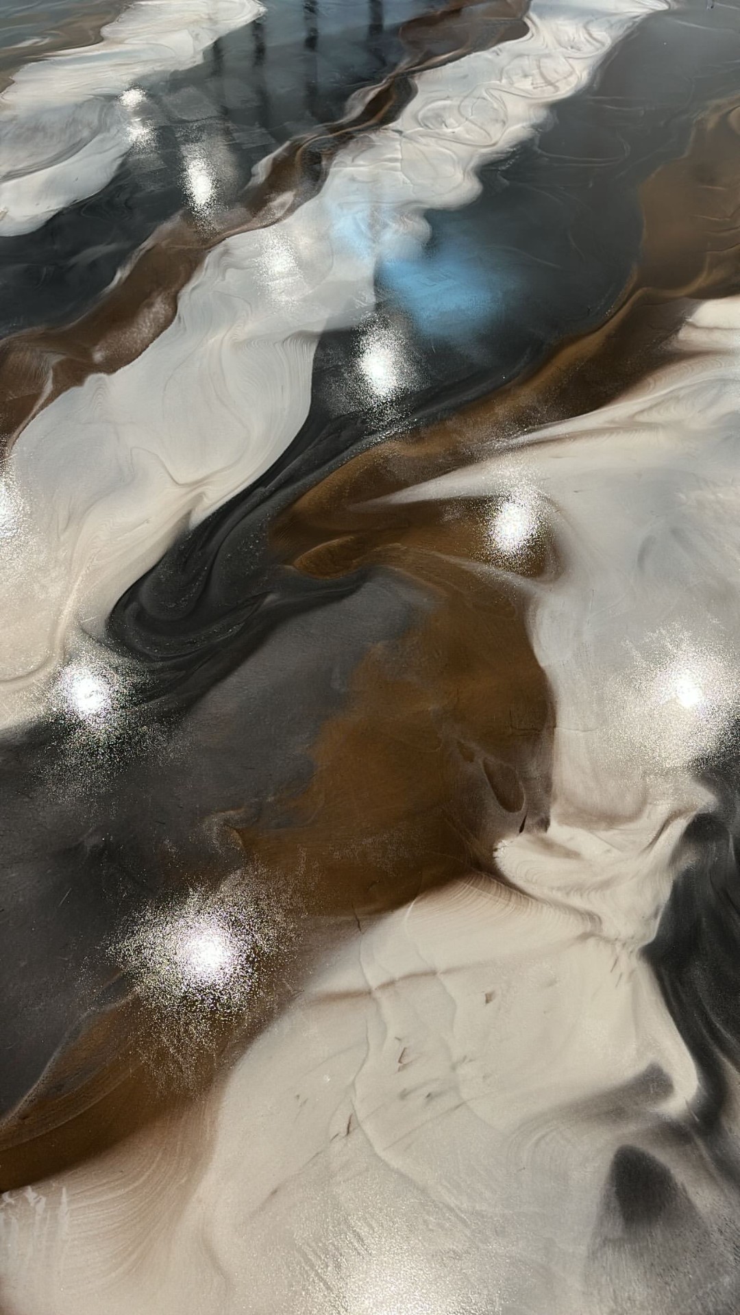 Signature metallic epoxy floor with white, black, and gold swirls